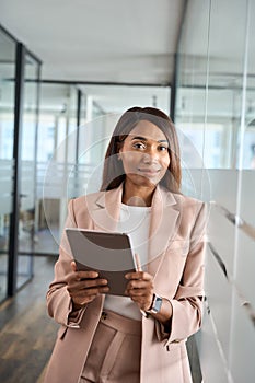 Young professional business woman holding tablet in office, vertical portrait.