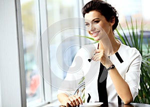 Young professional businesswoman sitting at cafe
