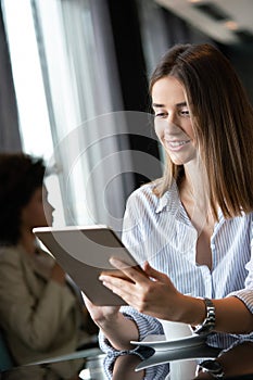 Young professional businesswoman sitting at table at cafe