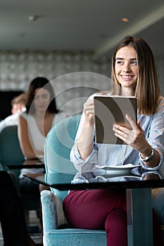 Young professional businesswoman sitting at table at cafe