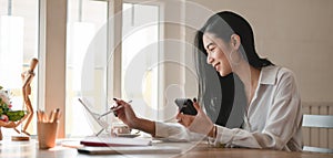 Young professional businesswoman working on her project with digital tablet in comfortable office