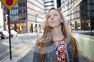 Young professional Caucasian woman walking on city street