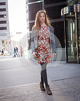 Young professional Caucasian woman walking on city street