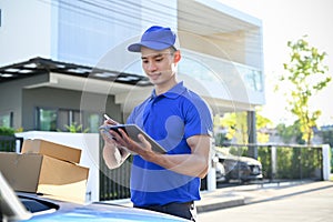 Young professional delivery man checking package on tablet before sending to the customer