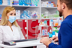 Young professional druggist give medications to customer in modern drugstore