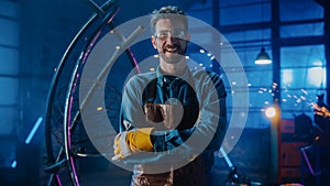 Young Professional Fabricator in Safety Glasses and Apron Gently Smiles at the Camera with Crossed