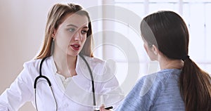 Young professional female general practitioner consulting patient in office.