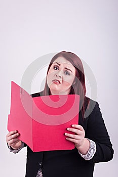 Young professional female holding an opened red file folder worried overwhelmed expression