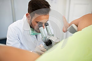 Young professional gynecologist exam patient with colposcope photo