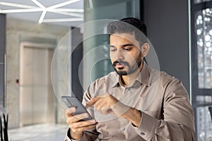 Young professional man using smartphone in modern office