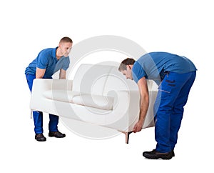 Young Professional Movers Placing The Sofa In New Home