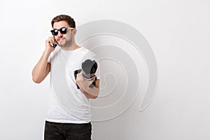 Young professional photographer in white shirt holds digital cam