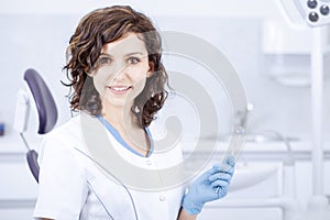 Young professional woman dentist in the dental office