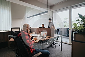 Young professionals collaborating in a modern office setting, discussing strategy and analysis using technology