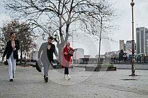 Young professionals walking outdoors in a park with urban background