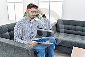 Young psychologist man at consultation office worried and stressed about a problem with hand on forehead, nervous and anxious for