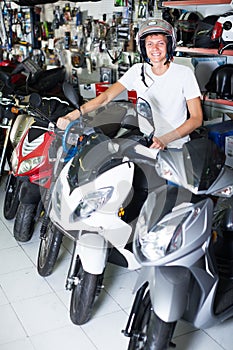 young purchaser sitting on the motorbike with helmet