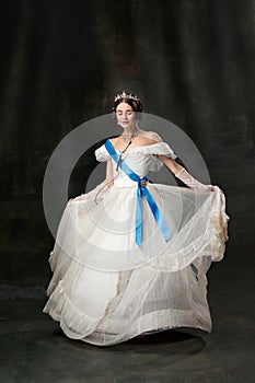 Young queen. Portrait of adorable girl in image of medieval royal person in renaissance style dress  on dark