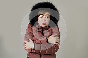 Young read hair attractive and sweet woman 20s or 30s posing isolated wearing warm winter jacket with fur hood shivering and freez