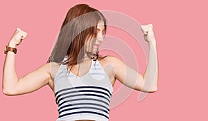 Young read head woman wearing casual clothes showing arms muscles smiling proud