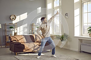 Young readhead man wearing casual clothes dancing in the living room at home