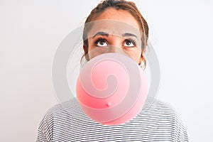 Young readhead modern woman chewing gum and doing air bubble