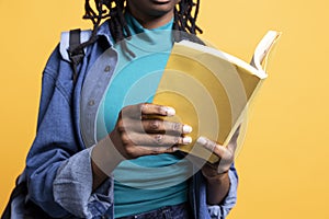 Young reading enthusiast with book in hands, studio background photo