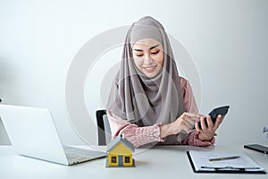 Young real estate agent counting and calculating her income and commision in the office room