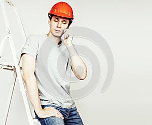 young real hard worker man isolated on white background on ladde
