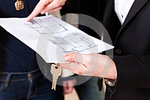 Young realtor explains lease agreement to couple photo