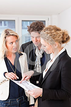 Young realtor explains lease agreement to couple photo