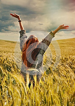 Young red hair woman standing back hands up to breathtaking view