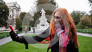 Young red hair woman using cell phone in Vienna, wide angle