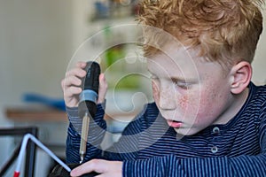 Young red haired boy by working