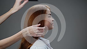 Young red-haired girl combing her hair.