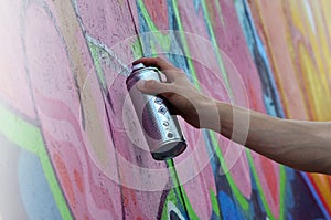 A young red-haired graffiti artist paints a new graffiti on the wall