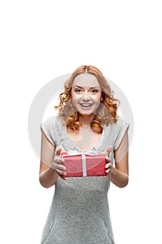 Young red-haired happy smiling girl holding gift