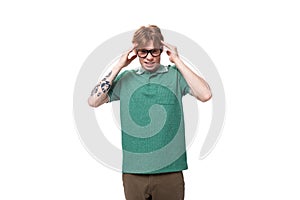a young red-haired man dressed in a green T-shirt is trying to concentrate on his thoughts