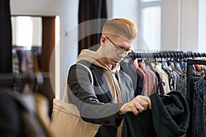 Young red haired man in thrift shop