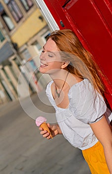 Young red haired Woman enjoying summer in the town