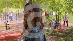 Young red haired woman looks at camera and smiles.