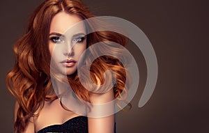 Red haired woman with voluminous, shiny and curly hairstyle. Flying hair. photo