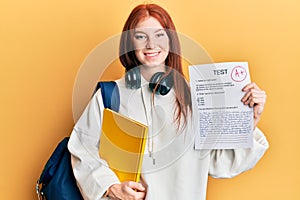 Young red head girl wearing student backpack holding passed test smiling with a happy and cool smile on face
