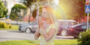 Young redhair woman sneezing in spring. Pollen Allergy symptoms