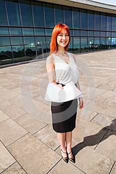 Young redhead business woman in formal outside