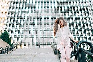 Young redhead business woman walking on the stairs