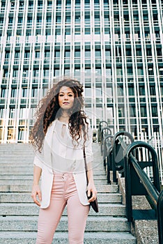 Young redhead business woman walking on the stairs