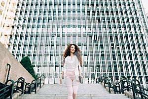 Young redhead business woman walking on the stairs