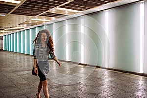 Young redhead business woman walking to work