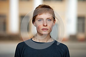 Young redhead caucasian woman serious face outdoor portrait